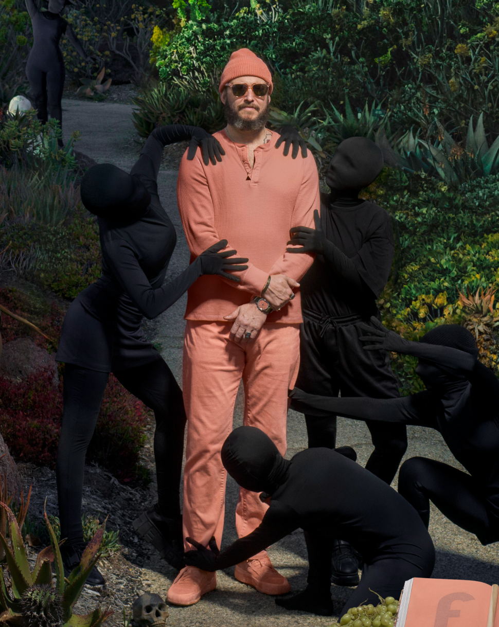 Le chanteur Bon Iver prend la pose au milieu d'un paysage naturel luxuriant, accompagné de silhouettes informes.