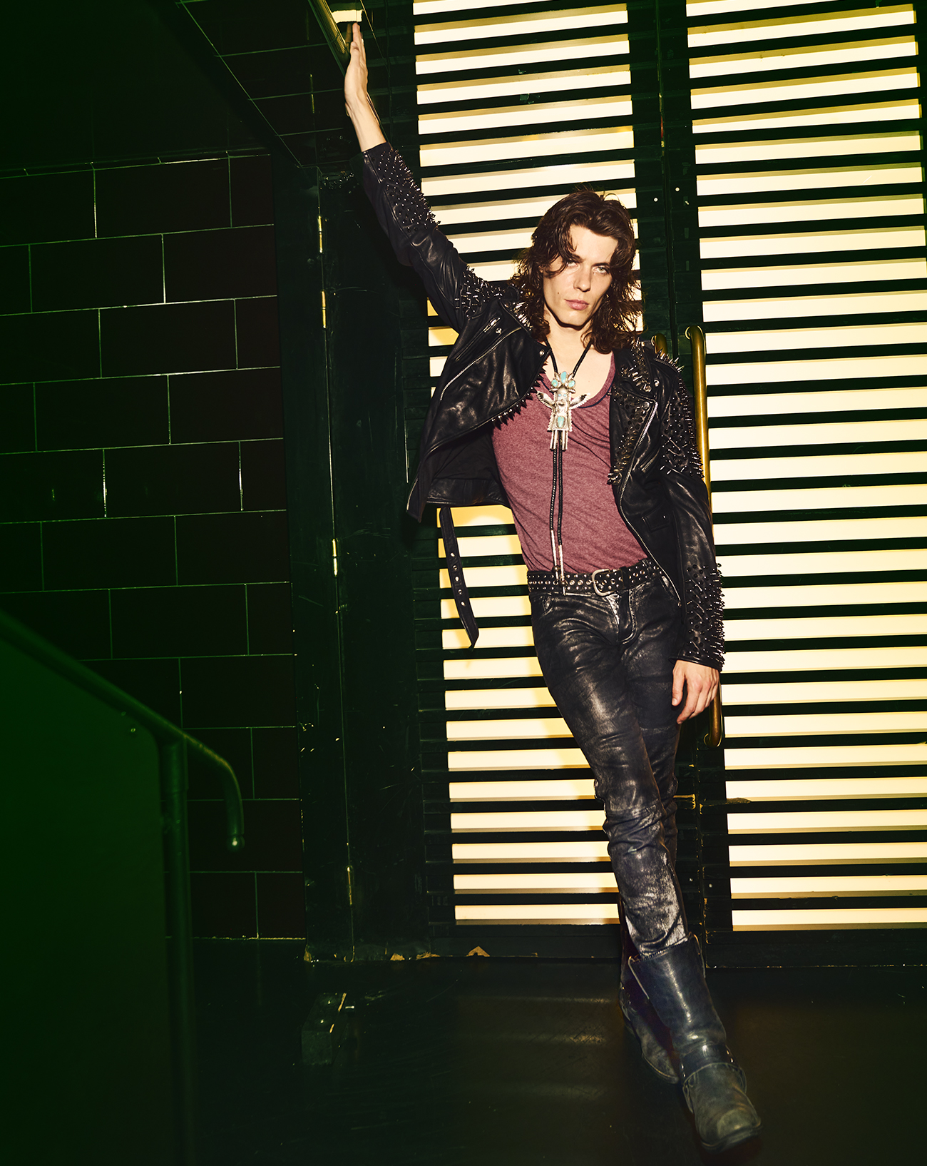 L'artiste Asphalt prend la pose allongé sur un canapé rouge, sélectionné dans les chanteurs à suivre selon Numéro © Elle Von Unwerth.